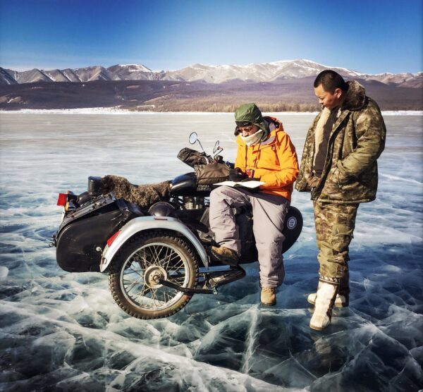 Il traverse un lac gelé en side car