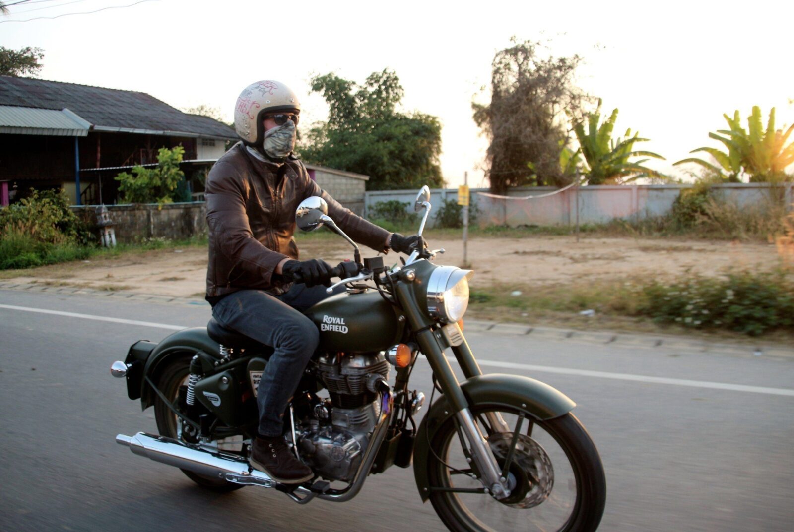 Rider on a Royal Enfield motorcycle on a quiet road in northern Thailand