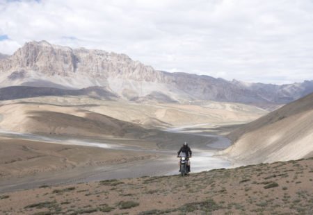 <h2>Quelle est ta plus grande prise de risque, et qu'est-ce que cela t'a apporté à titre personnel ? </h2>

Un ride légendaire du Ladakh : le Khalsar - Khardung La - Leh.... en moins d'1H45 montre en main en solo et par temps de pluie ! Pour ceux qui connaissent, cette route en si peu de temps est un vrai challenge à relever. 
 
La partie entre Khalsar et le col du Khardung est magnifique....une montée aux milles couleurs mais elle devient un challenge physique par temps de pluie.  Elle s'achève par un offroad boueux et caillouteux sur les 10 derniers kilomètres...et le tout pendant que l'air manque dans ton carbu et tes poumons. Le Khardung se mérite. Une fois atteint le col du Khardung, il faut redescendre à Leh. Cette deuxième partie commence par un autre offroad de 10km caillouteux, également emprunté par les camions de l'armée indienne qui viennent ralentir ton allure. Les Yaks stationnés dans les virages n'aident pas non plus. Ensuite de nombreuses épingles ponctuent la route jusqu'à Leh. Un manque d'attention à vive allure dans cette descente peut donc être fatal. 
 
A titre personnel, c'est un accomplissement d'avoir rider le Khardung qui est un rêve pour beaucoup de motards. La vue tout du long est un souvenir inoubliable. avec d'un côté les reflets or/cuivre des monts de la Nubra Valley et de l'autre les touches verdoyantes de la ville de Leh.  De plus, tenir ce chrono en bullet 500 sans détruire ses segments ou crever est épique. 
C'est pour cela qu'on l'aime notre bullet nan?! L’été dernier en 2019 pendant la saison ladakhi. Pour VR pour opérer la saison, est allé repérer les traces, ne connaissait pas du tout, a pris une bike VR pour se balader. A roulé trop vite, standard Bullet une nouvelle, avait 2000 km au monteur 