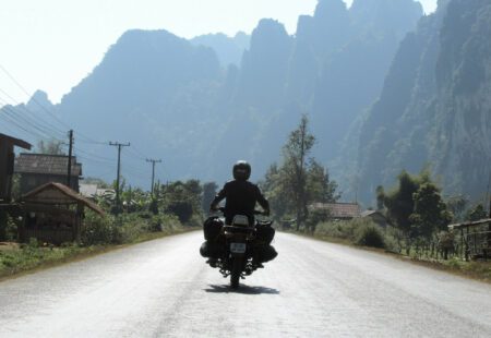 <h2>Derniers kilomètres</h2>

Une halte à Pakbeng, petite bourgade accrochée à flanc de montagne au-dessus du Mékong, et voilà notre dernière étape, au travers de la province de Sayaboury, plus sèche mais toujours sauvage et vallonnée. Après avoir hissé la moto sur un bac pour traverser le fleuve, les derniers kilomètres en le longeant au coucher du soleil, nous remplissent d’émotion et de nostalgie. Nous voilà déjà de retour à Luang Prabang, que nous croyons avoir quitté la veille, au terme d’un pèlerinage de 1000 km aux sources d’un Laos sauvage et mystérieux. Quel pays attachant, pétri de simplicité, de pudeur et d’authenticité! Nous sommes conquis et la Royal Enfield a trouvé une nouvelle terre d’accueil et pas des moindres.
